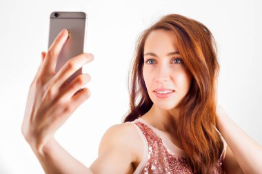 Bir selfie çekmeye akıllı telefonunu kullanarak ve gülümseyen genç kadın.