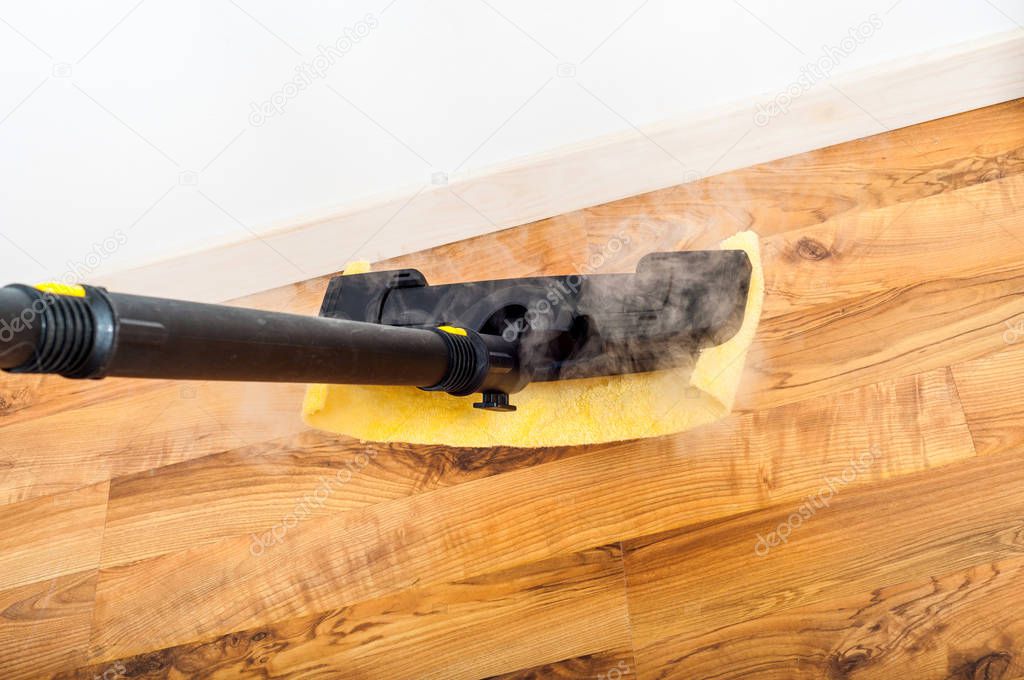 Wooden, parquet, laminate floors cleaning with steam in the room