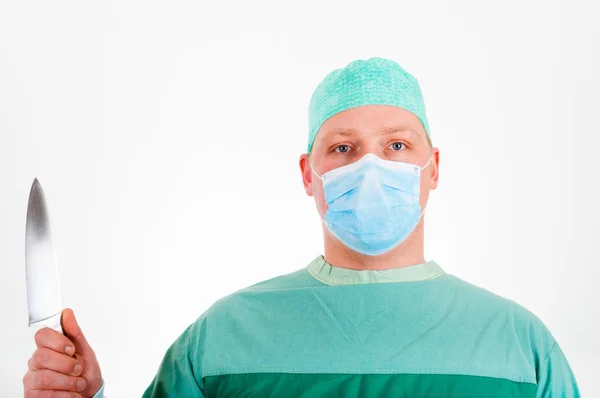 Человек в форме хирурга и с ножом в руке — стоковое фото