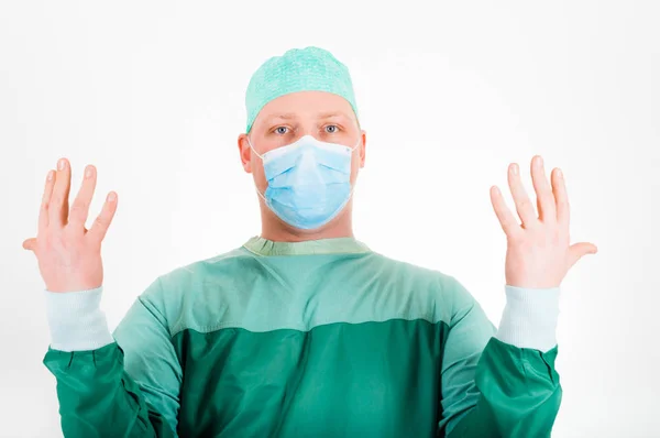Хирург в хирургической маске и кепке готовится к операции — стоковое фото