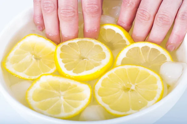 Citroensap, natuurlijke cosmetica. De vrouw vingernagels onderdompelen in — Stockfoto