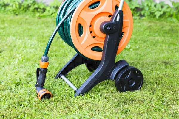 Bahçe Hortum reel, çim artalan üzerinde dolandı