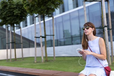 Güzel genç kadın güneş gözlüğü müzik dinleme görünümünü