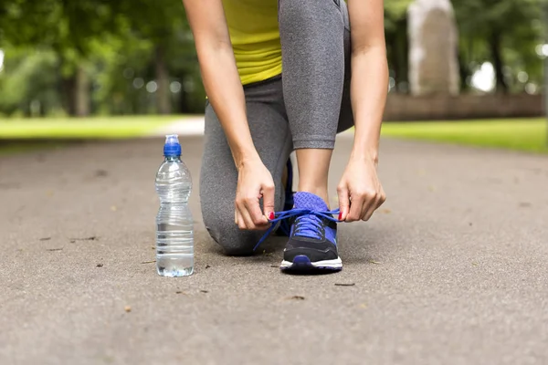 Genç kadın dantel koşu ayakkabıları daha önce eğitim bağlıyor. Sağlık