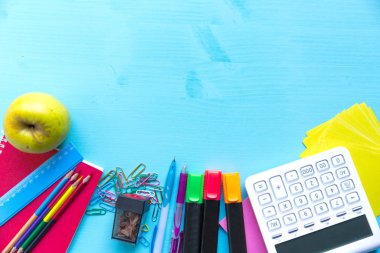 Okula dönelim. Okul için mavi ahşap bir masanın üzerinde eşyalar..