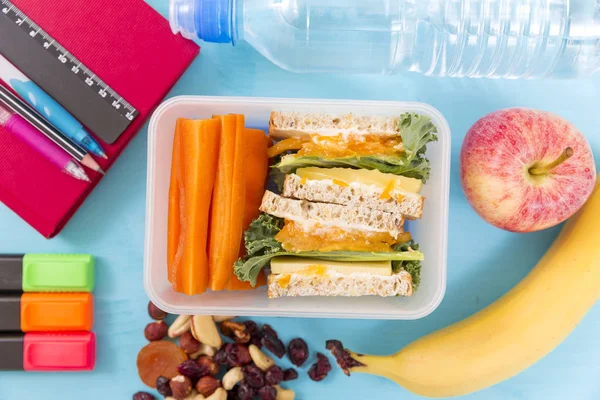 Boîte à lunch scolaire avec sandwich, légumes, eau, noix et frui — Photo