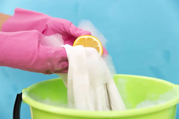 Close-up of cleaner woman hand removing stain from white cloth w