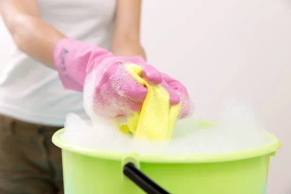 Close-up van schonere vrouw hand knijpen doek in emmer gevuld — Stockfoto