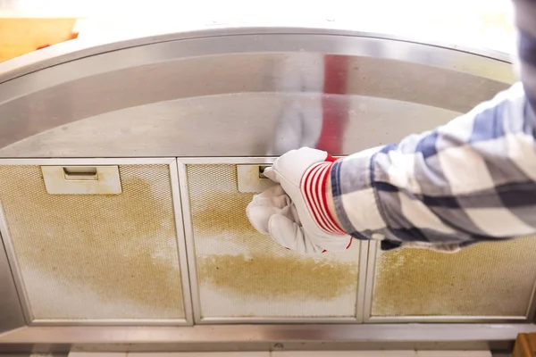 Reparador tomando sucia malla de aluminio filtro de la cocina h — Foto de Stock