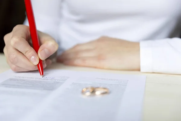 Women signs divorce papers and takes of the ring — Stock Photo, Image