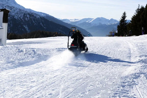 Ski resort staff member driving snowmobile. Ski resort in Italy Alps