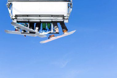 Güneşli kış gününde telesiyej parlak mavi gökyüzü-kayak merkezi İtalya karşı gidiş kayakçı.