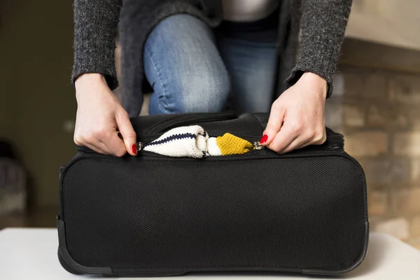 Woman packing for vacation travel trying to close full suitcase — Stock Photo, Image