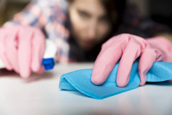 Vrouw in beschermende handschoenen is ijverig wit oppervlak schoonmaken — Stockfoto