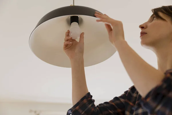Kobieta, Wymiana żarówki w domu. Oszczędzania energii, zmieniając Lampa Led — Zdjęcie stockowe
