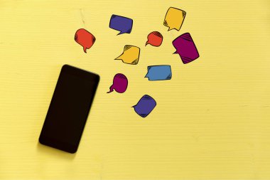 Sarı arka plan metin baloncuklar ile smartphone. İlet