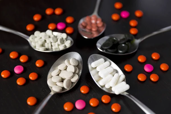 Varias píldoras medicinales, tabletas y cápsulas en cuchara — Foto de Stock