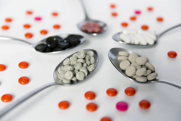 Varias píldoras medicinales, tabletas y cápsulas en cuchara — Foto de Stock
