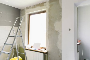 Ev yenileme kavramı. Mutfak onarım ve yenileme sürecinde. Merdiven ve inşaat araçları