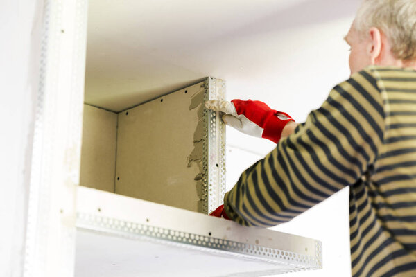 Plasterer home improvement handyman worker with putty knife work