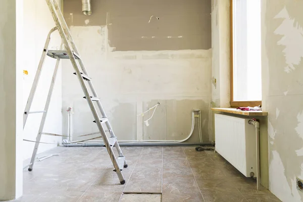 Concepto de renovación del hogar. Cocina en proceso de reparación y renovación. Escalera y herramientas de construcción —  Fotos de Stock