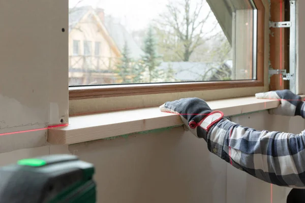 Home improvement handyman installing window sill in new build at — Stock Photo, Image
