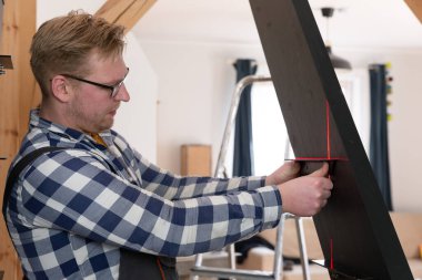 Ev dekorasyonu ustası merdivenleri doğal ışık altında inşa ediyor.