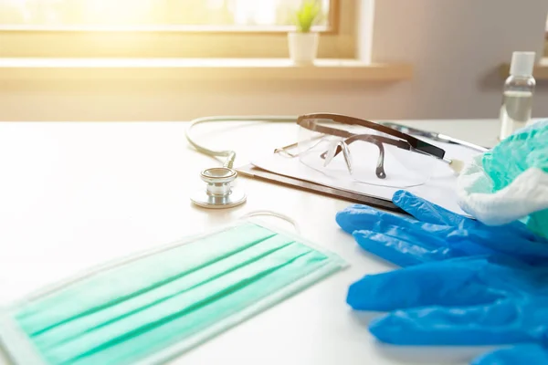 Doctors and nurses protection kit on a white table with sunny window