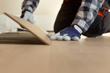 İnşaat işçisi, yenilenmiş tavan arasına kaplama döşeme kuruyor. Ev geliştirme kavramı.