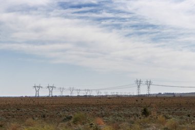 Güç hatları birbirine zincirlenmiş, mesafeye doğru gidiyorlar.