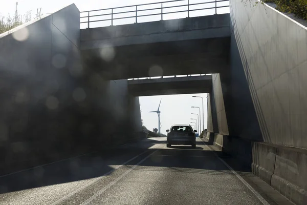 Autosnelweg met windturbine aan de horizon — Stockfoto