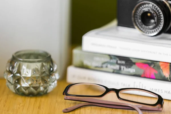Glasögon bredvid böcker på natten — Stockfoto