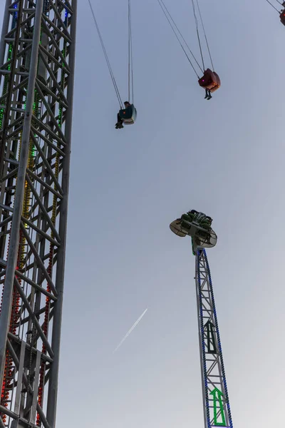 Carnaval paseos cerca uno del otro con avión en el fondo — Foto de Stock