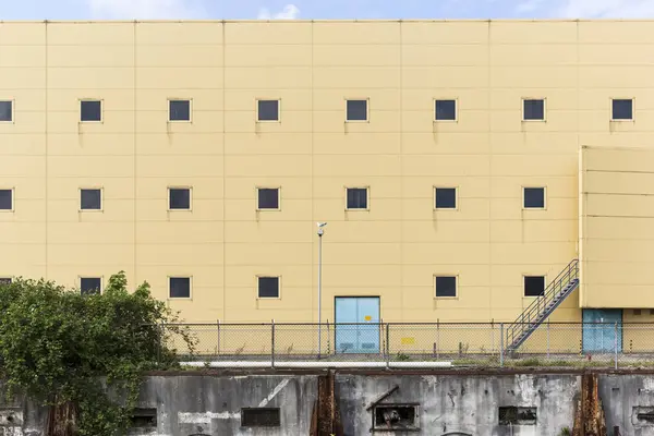 Индустриальная стена с чайкой, сидящей на вершине легкого опроса — стоковое фото