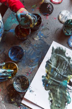 Çocukların resim masasını kaplayan dağınık parmak resimleri.