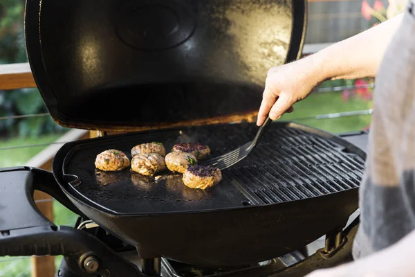 Man Flipping Burger On Home Barbecue Setup — Stock Photo, Image