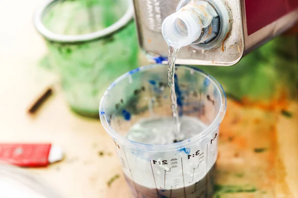 Alcohol metilado vertiendo en la taza de medición de pintura — Foto de Stock