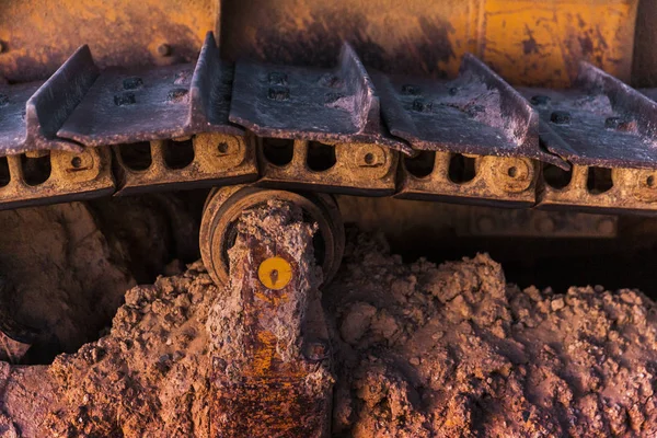Barro seco atascado en viejo tractor amarillo vintage con luz natural al atardecer — Foto de Stock