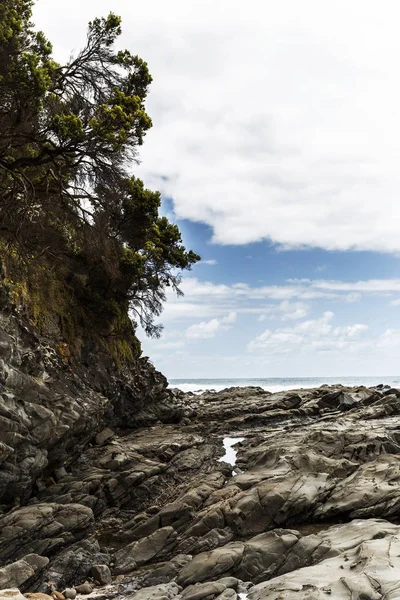 Falaise escarpée au bord de la plage le jour couvert — Photo