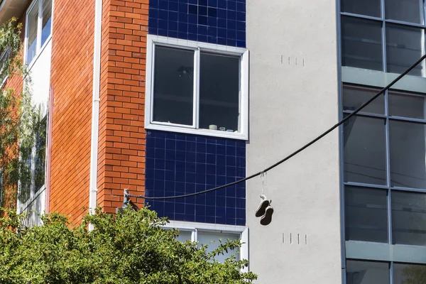 Zapatos colgando de la línea eléctrica en la tranquila calle suburbana — Foto de Stock