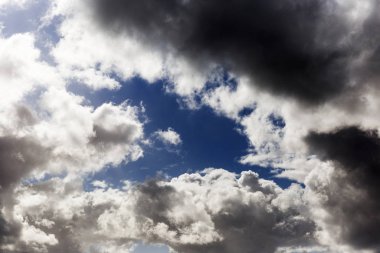 Mavi gökyüzünde fırtına bulutları yaklaşıyor.