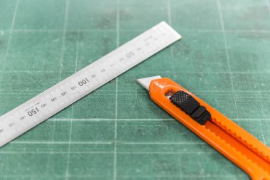 Stanley bıçak cetveli eski yeşil kesme tahtasının üzerine yerleştirildi