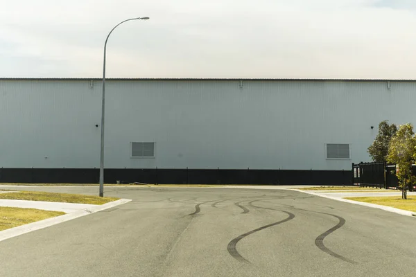 Marcas de desgaste de neumáticos de automoción dejadas en el parque empresarial industrial de asfalto — Foto de Stock