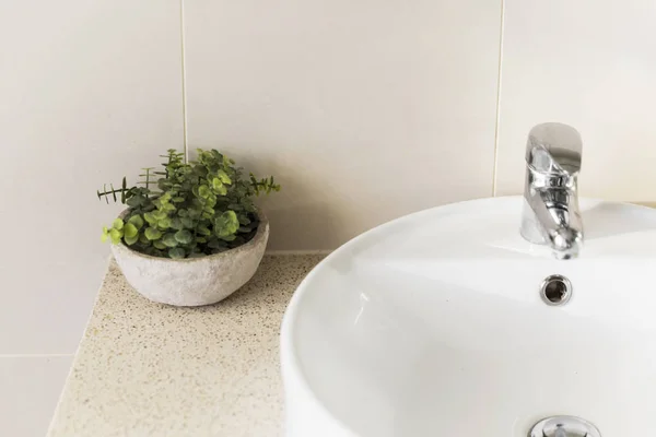 Minimální domácí koupelna umyvadlo a plastové rostliny dekor — Stock fotografie