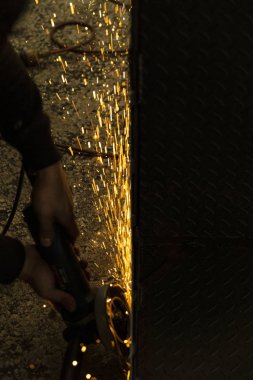 Turuncu kıvılcım metal ürünün yanında dikey uçuyor