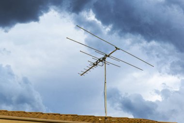 Televizyon anteni fırtına gelmeden önce konutun önünde dik duruyor.