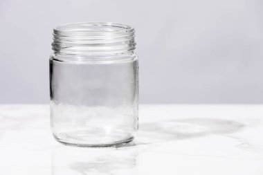 Beyaz mermer yüzeyde boş cam kavanoz