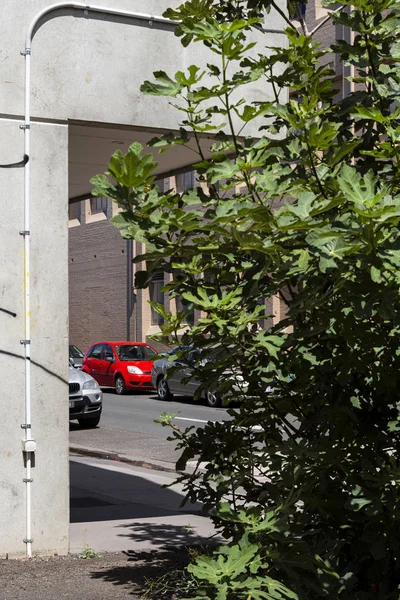 Aire de jeux en béton avec voiture rouge vif garée sur la rue latérale — Photo