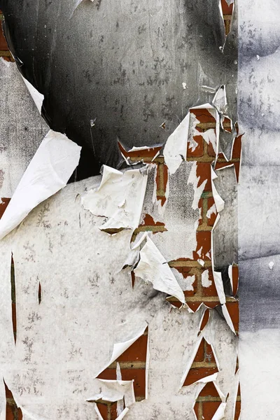 Zerrissenes texturiertes weißes Papier, das auf grungy Ziegelwand-Oberfläche gepostet wird — Stockfoto