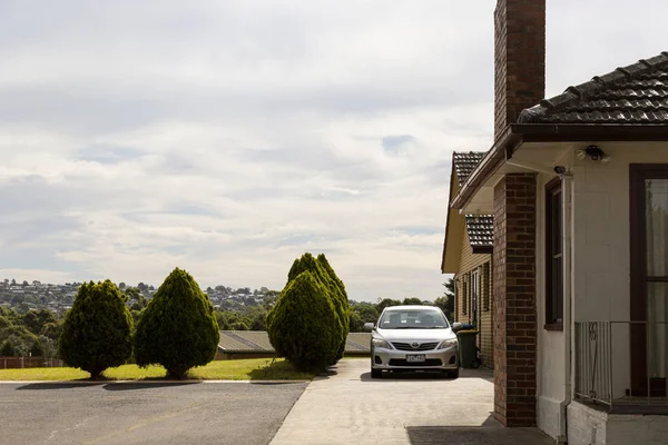 Maison & voiture perchée au sommet d'une colline avec vue sur la banlieue — Photo